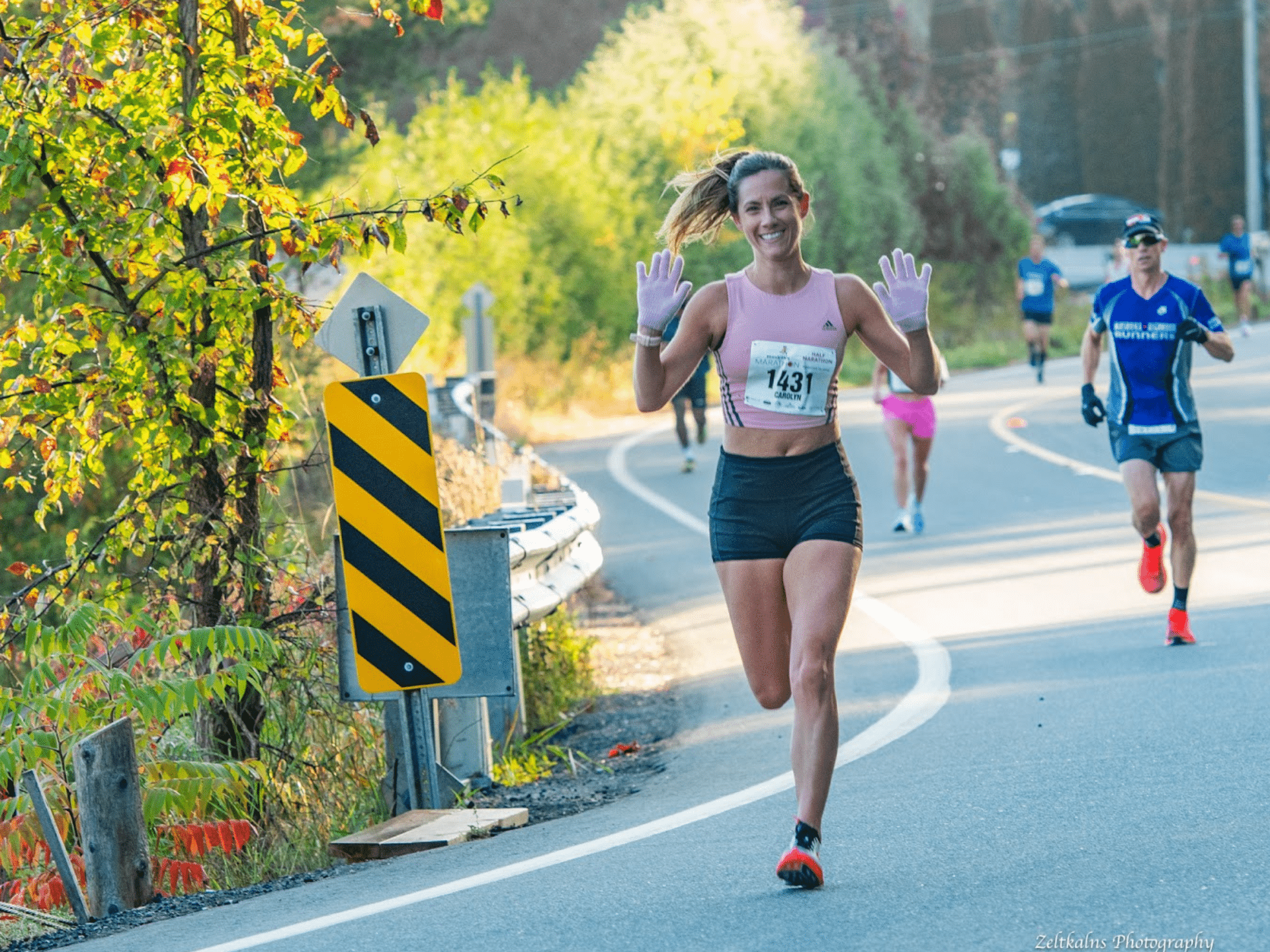 Muskoka Marathon race runner waving with two hands to the camera