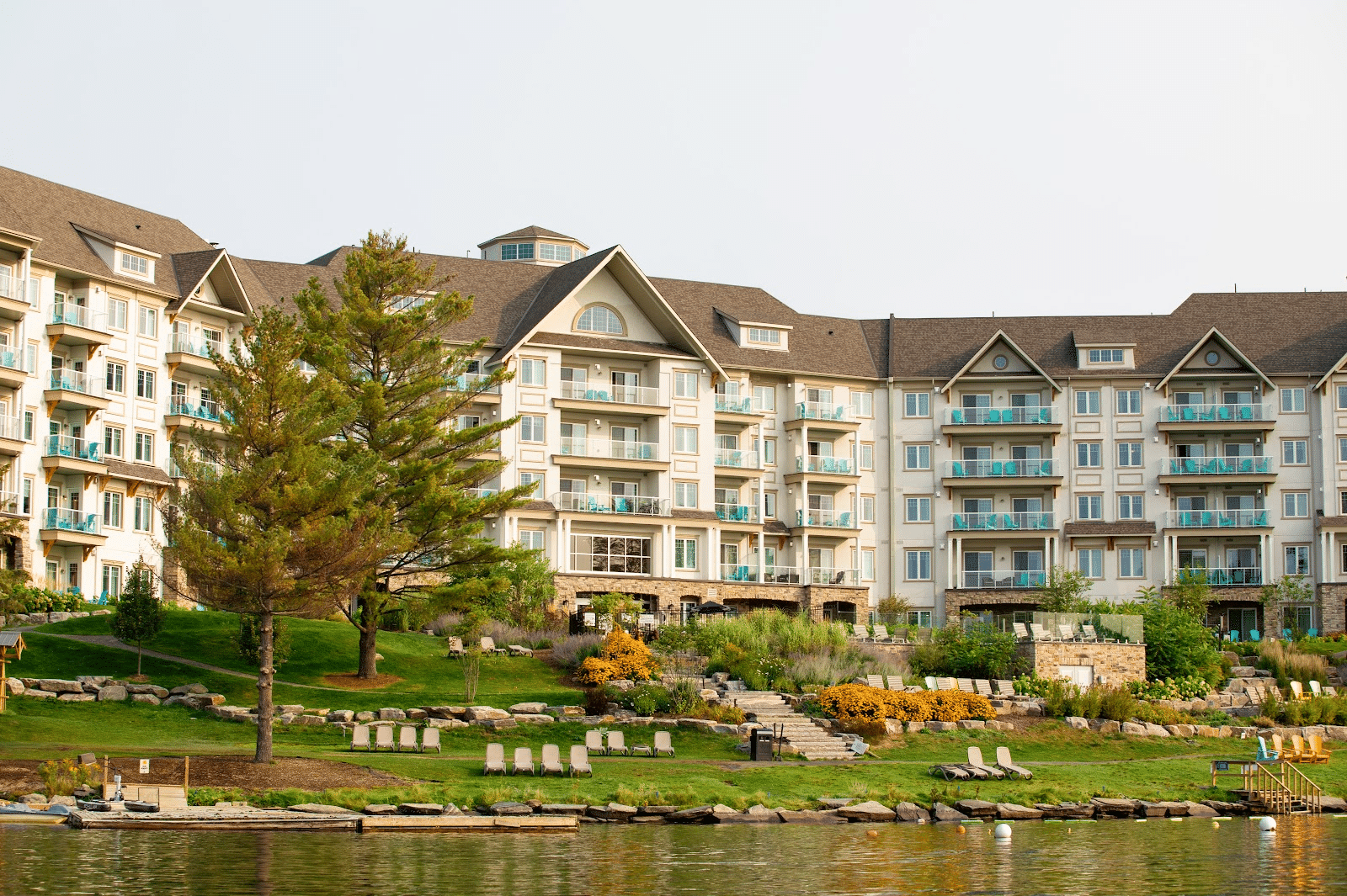 Deerhurst Resort’s lakeside hotel exterior framed by early fall colour on Peninsula Lake.